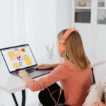 Jovem usando fones de ouvido e laptop em um ambiente de trabalho acolhedor, representando a criação de uma plataforma EAD