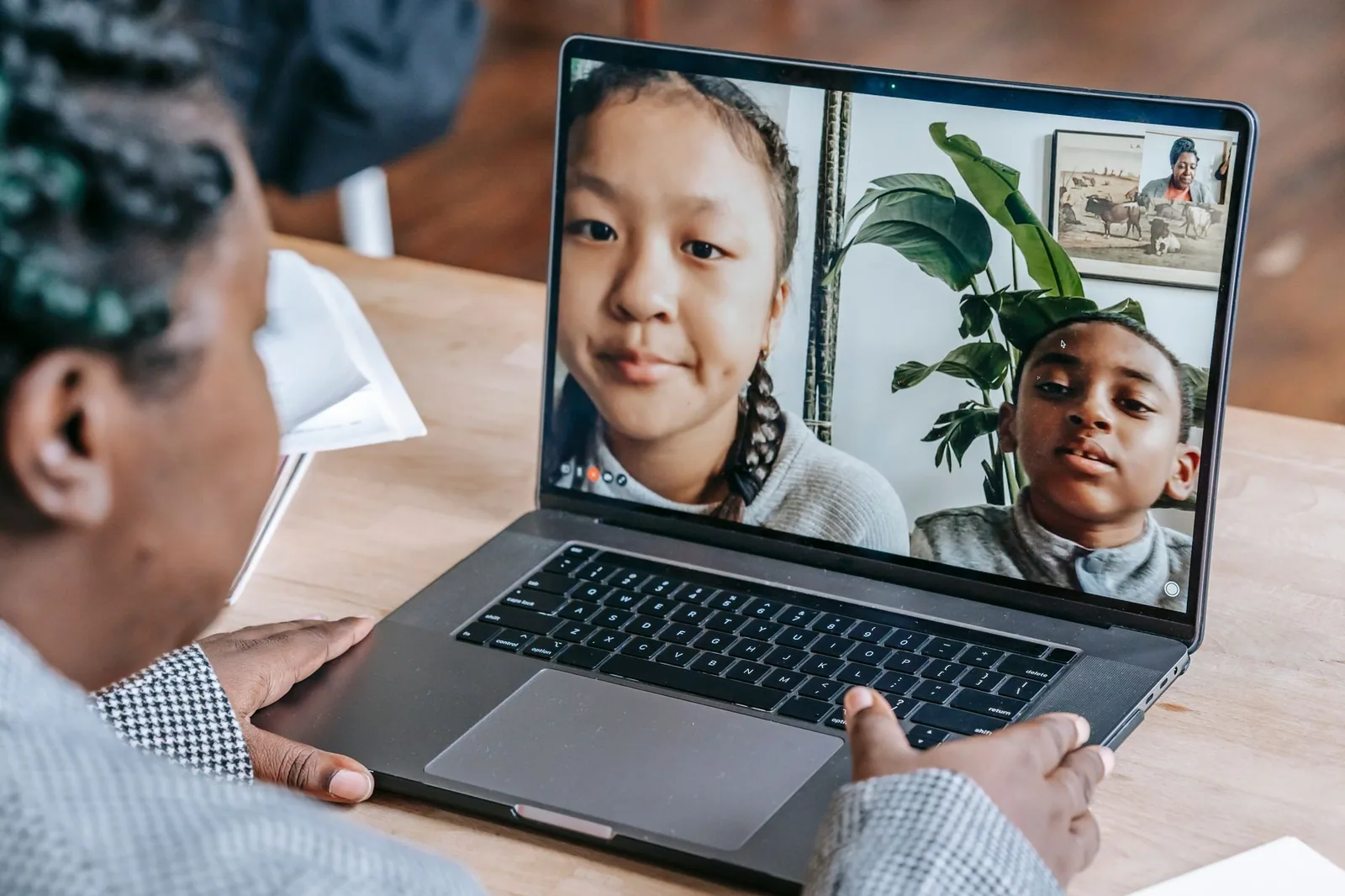 Professor negro respondendo perguntas de alunos online em um laptop, ilustrando a escolha de ferramentas para EAD